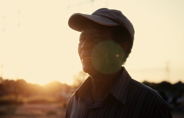 african man with hat on with sunset in the background