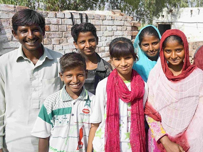 Latif and his daughter Sobia stand each side of her younger brothers and sisters