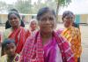 Santal Christian women in Bangladesh. Behind them are some of the new brick homes which Barnabas Aid built for them after their old wooden homes were deliberately burnt to the ground