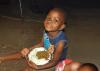 A hungry Christian girl in Zimbabwe eating a serving of protein-rich lentils