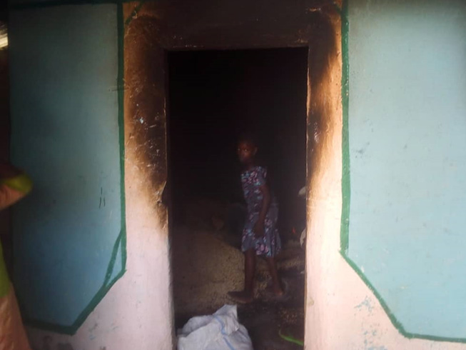 Villagers try to salvage grain from a food store burnt out in Boko Haram's attack on Grossi